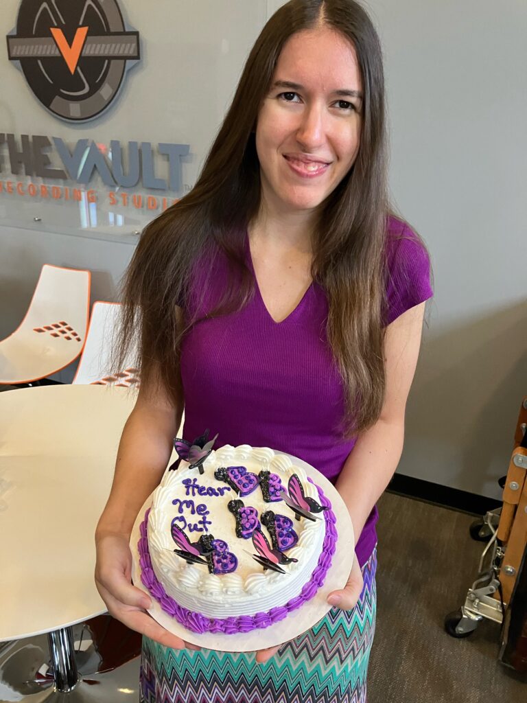 Demi Michelle holding her Hear Me Out cake at the studio