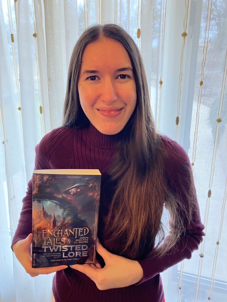 Demi smiling with her copy of Enchanted Tales & Twisted Lore