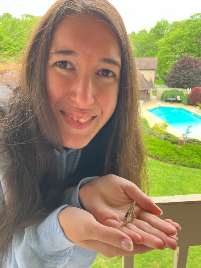 Demi smiling with a butterfly on her hand