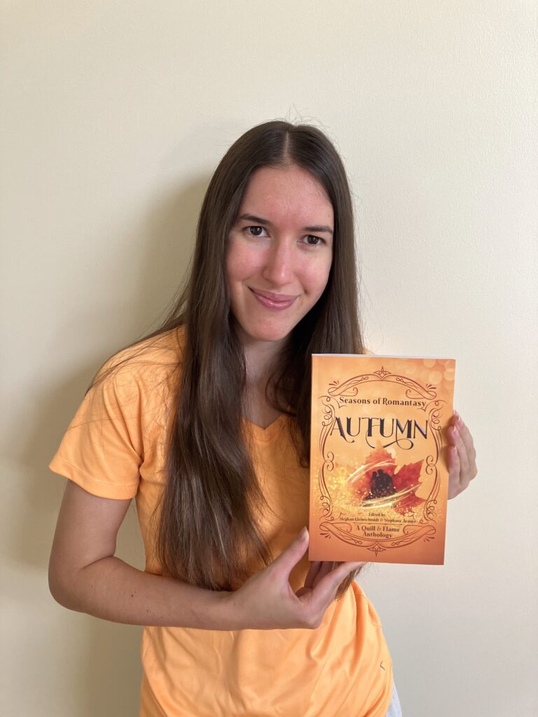 Demi smiling with her copy of Seasons of Romantasy: Autumn